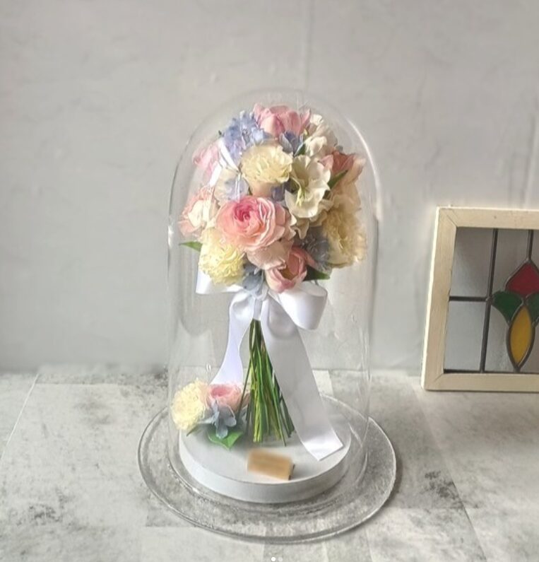淡いピンクとホワイトの花束を保存したガラスドームアフターブーケ
