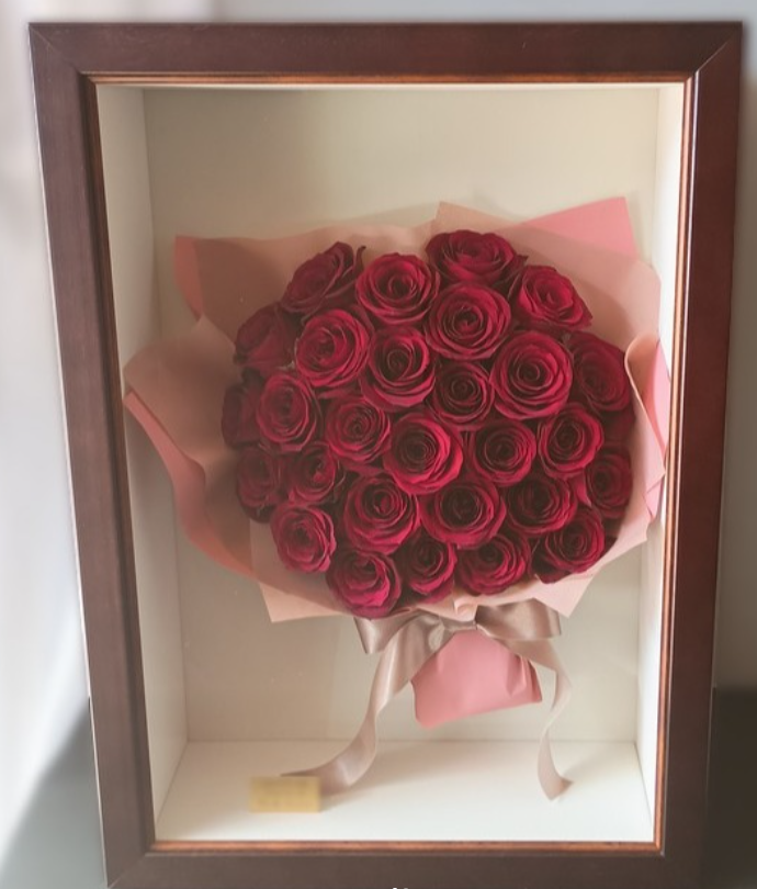 赤バラの花束をラッピングとリボンとともにブラウンの立体フレームへ保存した作品事例